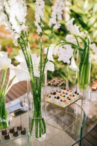 Mesa de convidados decorada com vidros e flores no Espaço Província
