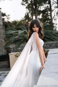 noiva usando vestido com capa fluida de tule criando movimento delicado
